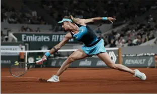  ?? THIEBAULT CAMUS — THE ASSOCIATED PRESS ?? Ukraine’s Lesia Tsurenko plays a shot against Poland’s Iga Swiatek during their first-round match at the French Open in Paris on Monday. Swiatek cruised to a 6-2, 6-0victory to advance in the tournament.