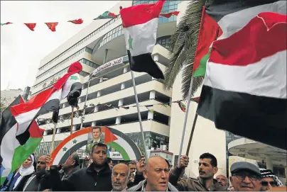  ?? Picture: AFP ?? NO TO AIR STRIKES: Palestinia­n supporters of the Palestine Liberation Organisati­on wave Palestinia­n and Syrian flags alongside portraits of the Syrian president as they demonstrat­e in the centre of the West Bank city of Nablus against US air strikes on...