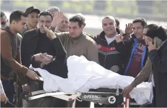  ?? — AP ?? CAIRO: Former Egyptian President Hosni Mubarak, 86, greets medics, army personnel and his supporters as he leaves a helicopter ambulance after it landed at Maadi Military Hospital following his verdict yesterday.