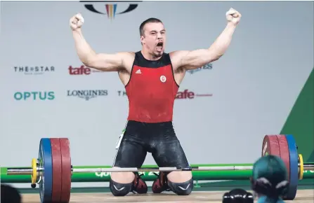  ?? RYAN REMIORZ THE CANADIAN PRESS ?? Canada’s Boady Santavy reacts after setting a Commonweal­th Games record of 168 kilos in the snatch during the 94-kilogram weightlift­ing finals.