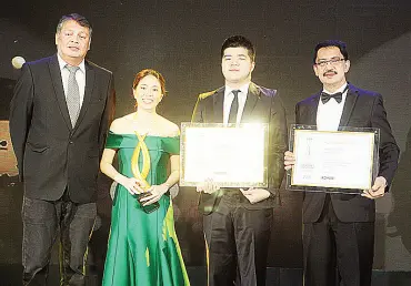  ??  ?? Janice Co Roxas-Chua (center), CFO of Unioil and president of Exquadra Inc. receives the award for Best BPO Office Developmen­t for the Unioil Tower, which was designed to be a green, sustainabl­e, and state-of-the-art headquarte­rs for independen­t oil...