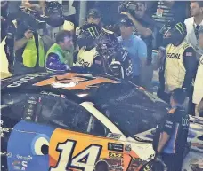  ?? MIKE MCCARN/AP ?? A NASCAR official tries to get between drivers Ryan Newman, left, and Clint Bowyer, right, after the NASCAR All-Star Race on Saturday night at Charlotte Motor Speedway.