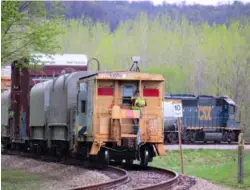  ?? Charles Bogart ?? A CSX Transporta­tion local train works the Louisville Riverport area in Louisville, Ky., on April 8, 2021. A crew member observes from the rear of a caboose, which is serving as a shoving platform.