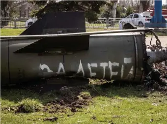  ?? Getty images pHotos ?? ‘FOR THE CHILDREN’: The remains of a rocket that hit a train station in Kramatorsk, Ukraine, likes in the grass. The attack killed at least 52 people. Below, a woman from Bucha, Ukraine, cries over the grave of her son, who was buried in her garden.