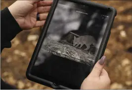  ?? CARIN DORGHALLI — ENTERPRISE-RECORD ?? Hannah Braden, president of Friends United in Rescue Inc., scrolls through photograph­s taken by cameras in Berry Creek. She finds that a fox ate some of the food she left for feline fire survivors on Wednesday.