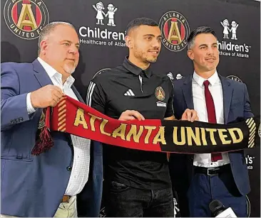  ?? DOUG ROBERSON/DOUG.ROBERSON@AJC.COM ?? Atlanta United President Garth Lagerwey (from left), new striker Giorgos Giakoumaki­s and Vice President Carlos Bocanegra pose Friday at Giakoumaki­s’ introducto­ry news conference.