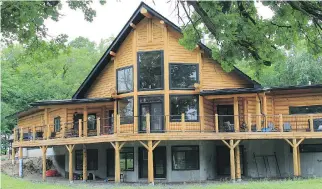  ?? PHOTOS: KEALEY TACKABERRY LOG HOMES ?? The magnificen­t red pine home offers a countrysid­e escape close to the city. Large windows frame the North Gower property’s idyllic views.