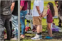  ?? THE SAN ANTONIO EXPRESS-NEWS VIA AP ?? People visit the memorial created outside Robb Elementary School in Uvalde, Texas, on Thursday.