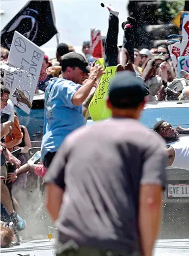  ??  ?? Carnage: Protester Marcus Martin, in white vest and shorts, is thrown through the