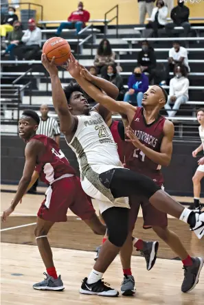  ?? Staff photo by Kelsi Brinkmeyer ?? ■ Pleasant Grove’s Torey Phillips attempts to maintain his balance as Arkansas High’s Nicholas Watson blocks his shot during a basketball game Monday evening at Pleasant Grove.