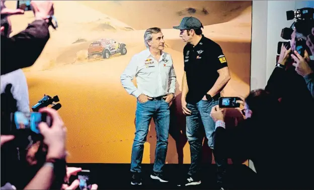  ?? ÀLEX GARCIA ?? Carlos Sainz y Nani Roma conversan en un acto de Mini en Madrid; ambos posaron a petición de La Vanguardia para esta serie del Dakar