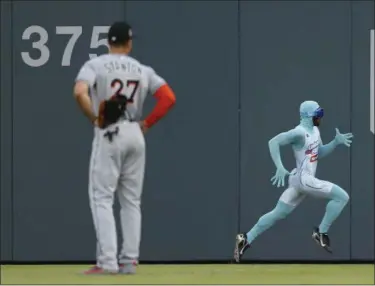  ?? JOHN BAZEMORE — THE ASSOCIATED PRESS ?? Braves grounds crew member and former college track star Nigel Talton runs past Marlins right fielder Giancarlo Stanton as he races a fan from the left field corner to the right field corner during the “Beat The Freeze” promotion June 23 in Atlanta.