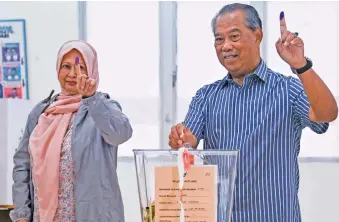  ?? Picture: AFP ?? MAKING A MARK. Malaysia’s former prime minister Muhyiddin Yassin, right, showing his inked finger while casting his ballot at a polling station during the general election in Muar, Malaysia’s Johor state.