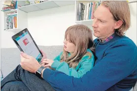  ?? KELVIN CHAN THE ASSOCIATED PRESS ?? Paddy Kelly and his daughter, Ailish, use gohenry, one of a wave of digital banking apps for children, in London.