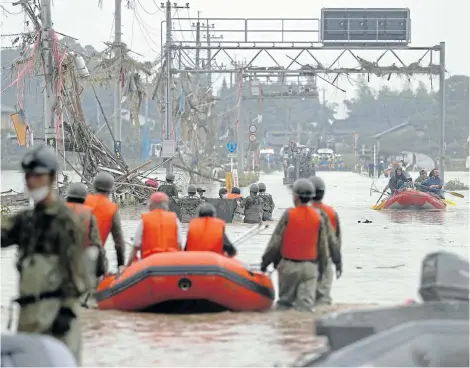  ?? Picture:KYODO via REUTERS ?? FLOOD DISASTER: Residents are rescued by Japanese Self-Defence Force soldiers using a boat at a flooding area caused by heavy rain in Kuma village, Kumamoto prefecture, southern Japan yesterday