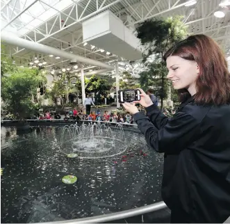  ?? DARREN MAKOWICHUK ?? Tia Fulton enjoys the water feature Tuesday at Devonian Gardens after it reopened.
