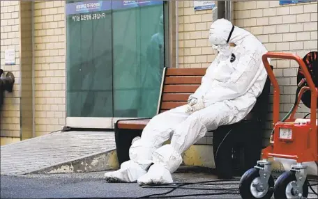  ?? Im Hwa-young Yonhap ?? A MEDICAL worker rests outside a hospital in Daegu. South Korea accounts for the largest number of COVID-19 patients outside China.