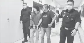  ??  ?? KE PENJARA: Rushdan (dua kanan) bersama Heriyanto (dua kiri) diiring polis selesai prosiding.