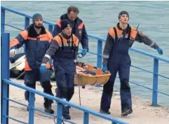  ?? GETTY IMAGES ?? Russian rescuers carry a stretcher with a body recovered Sunday after a Russian military plane crashed in the Black Sea outside Sochi, Russia.