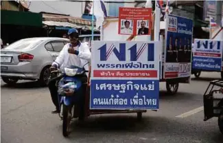  ?? [ FOTO AFP] ?? Penyokong calon Parti Phue Thai berkempen dengan menunggang motosikal di wilayah selatan Narathiwat, kelmarin.