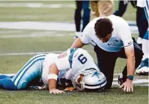  ?? Elaine Thompson / Associated Press ?? Cowboys quarterbac­k Tony Romo is tended to by a trainer after going down on a play in Thursday’s preseason game against Seattle. Romo suffered a broken bone in his back.