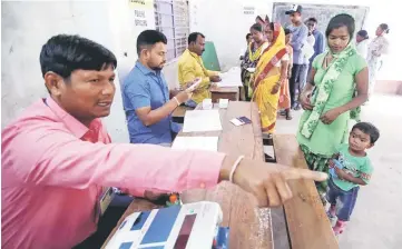  ??  ?? An election official guides a woman as she arrives to vote at a polling station during the first phase of general election in Alipurduar district, in the eastern state of West Bengal, India.