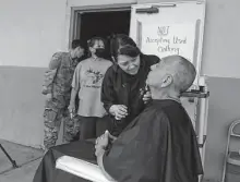  ?? Cedar Attanasio / Associated Press ?? Wildfire evacuee Domingo Martinez gets a haircut from Jessica Aragón outside an emergency shelter in Las Vegas, N.M.