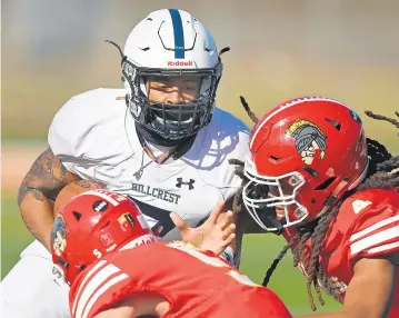  ?? BRIAN O’MAHONEY/DAILY SOUTHTOWN ?? Hillcrest quarterbac­k Caleb Treadwell, left, tries to get past Tinley Park’s Jack Butler and Edward Loggins during Friday’s game.