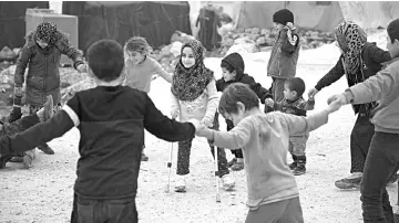  ??  ?? Maya Merhi (centre) plays with her friends in the Internally Displaced Persons (IDP) camp of Serjilla in northweste­rn Syria next to Bab al-Hawa border crossing with Turkey. — AFP photo