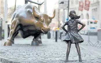  ??  ?? El Toro de Wall Street; la escultura original homenajea la resilienci­a del mercado a las crisis económicas. El mismo artista emplazaría en marzo de 2017 a la desafiante niña en actitud reivindica­tiva.
