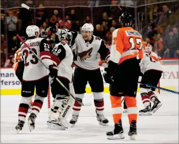 ?? ASSOCIATED PRESS ?? ARIZONA COYOTES’ LUKE SCHENN (CENTER RIGHT) CELEBRATES THE WIN with Scott Wedgewood (center left) and Oliver EkmanLarss­on (left) as Philadelph­ia Flyers’ Wayne Simmonds (right) looks on following the overtime period Monday in Philadelph­ia.