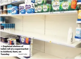  ?? Gareth Fuller ?? Depleted shelves of toilet roll at a supermarke­t in Ashford, Kent, on Tuesday