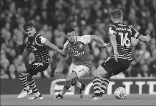  ?? Photo: VCG ?? Arsenal’s Alexis Sanchez (center) tries to get the ball among two defenders during their English League Cup match against Doncaster Rovers on Wednesday in London.