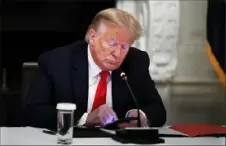  ?? Alex Brandon/Associated Press ?? President Donald Trump looks at his phone during a roundtable June 20 in the State Dining Room of the White House in Washington.