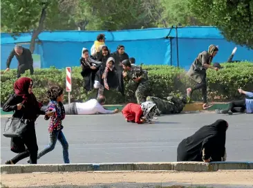  ?? AP ?? Civilians try to take shelter as militants open fire during a military parade marking the 38th anniversar­y of Iraq’s 1980 invasion of Iran, in the southweste­rn city of Ahvaz.