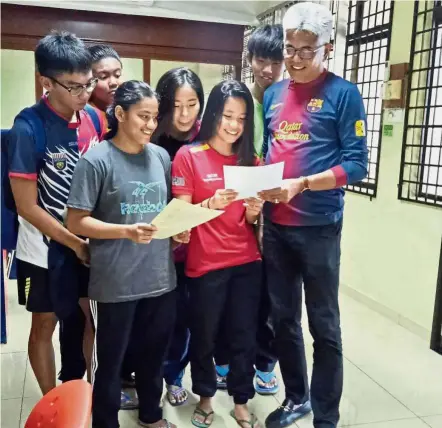  ??  ?? Balancing act: Tunku Mahkota Ismail Sports School principal Suhaimi Sun Abdullah (right) looking at the PT3 results of his students last year.