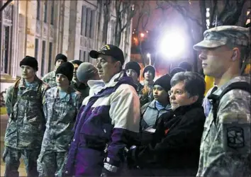  ?? Darrell Sapp/Post-Gazette ?? Charlie and Carol Resh, center, parents of Capt. Mark Resh, stand with ROTC cadets on the east side of the Cathedral of Learning before the start of the physical training session.