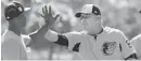  ?? LLOYD FOX/BALTIMORE SUN ?? Ron Johnson high-fives with a group of pitchers after finishing drills in Sarasota, Florida, in 2018.