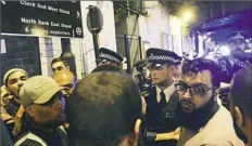  ?? Yui Mok/PA via AP ?? Police officers talk with local people early Monday near the Finsbury Park Mosque in north London, where a vehicle struck pedestrian­s, causing several casualties.