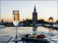  ?? COURTESY AIRE ANCIENT BATHS ?? Views of Seville’s storied Giralda Tower can be seen from the rooftop of Aire Ancient Baths where a fruit snack and glass of bubbly can be enjoyed.