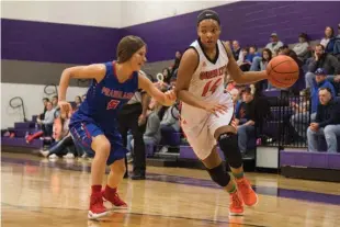  ?? Staff photo Joshua Boucher ?? Queen City’s Jessica Jones powers down the court as Prairiland’s Lauren Miller attempts to block on Feb. 13 at Mount Vernon High School.