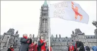  ?? GOVERNMENT OF CANADA PHOTO ?? Prime Minister Justin Trudeau helps to raise the World Aids Day flag on Parliament Hill in this 2016 file photo.