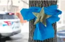  ?? | ASHLEE REZIN/ SUN- TIMES ?? Blue ribbons and gold stars in honor of CPD Cmdr. Paul Bauer were tied to trees near the family’s Bridgeport home Wednesday.