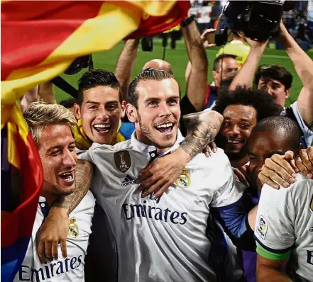  ??  ?? Racing against time: Gareth Bale (centre) celebratin­g with Real Madrid team-mates after their La Liga title triumph last week. He is expected to recover from his injury but there is doubt about his fitness going into the Champions League final against...