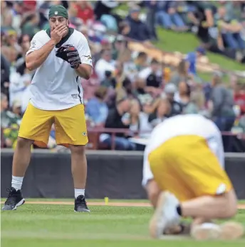  ?? RON PAGE / USA TODAY NETWORK-WISCONSIN ?? David Bakhtiari watches linebacker Clay Matthews fall after being hit in the face by a batted ball during the Green & Gold Charity Softball Game at Fox Cities Stadium on Saturday.