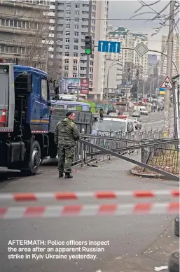  ?? ?? AFTERMATH: Police officers inspect the area after an apparent Russian strike in Kyiv Ukraine yesterday.