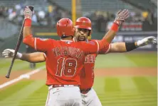  ?? Thearon W. Henderson / Getty Images ?? Luis Valbuena greets Albert Pujols at home plate after the Angels’ designated hitter hit the 596th home run of his career.