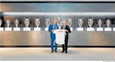  ?? REALMADRID.COM ?? Ancelotti posa junto a Florentino Pérez con la camiseta madridista delante de las Copas de Europa.