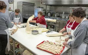  ?? Benjamin B. Braun/Post-Gazette ?? Women work on an assembly line making homemade ravioli at The Ladies of the Dukes in New Castle.