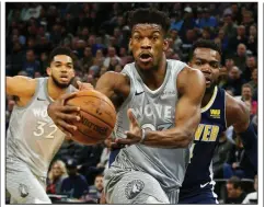  ??  ?? Jimmy Butler, AP/JIM MONEa guard for the Minnesota Timberwolv­es, drives to the basket past the Denver’s Paul Millsap during the first half of a game in April. Butler escalated his trade request drama Wednesday by challengin­g Coach Tom Thibodeau and a few players during practice.